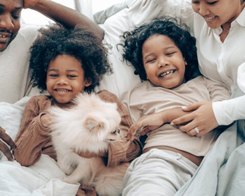 cheerful multiracial family having fun in bed during weekend