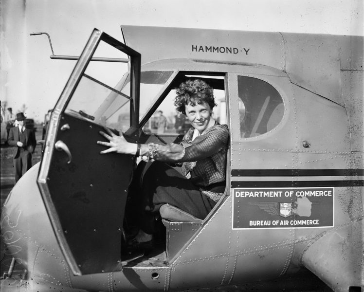 Amelia Earhart on her plane - Amelia Earhart Facts For Kids